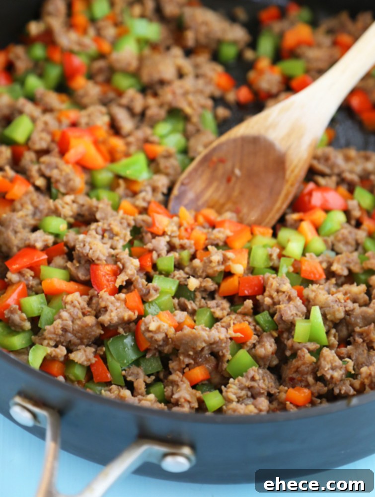 Close-up view of creamy Spicy Sausage and Bell Pepper Mac and Cheese with a spoon, highlighting the texture and ingredients.