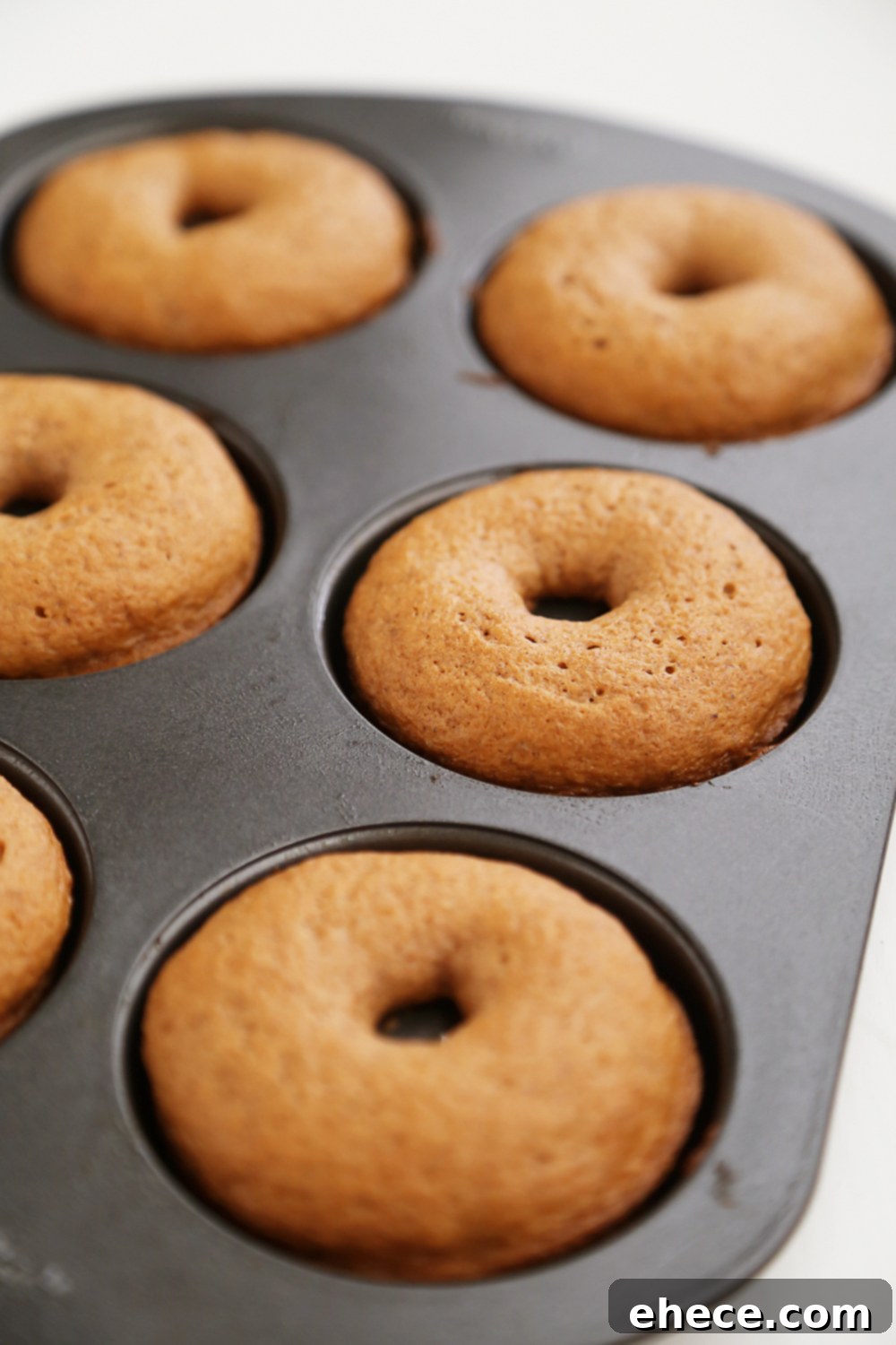 Pillowy Pumpkin Doughnuts with Dreamy Cream Cheese Frosting 3 Close-up of baked pumpkin donuts, showing their soft texture and golden-brown tops.