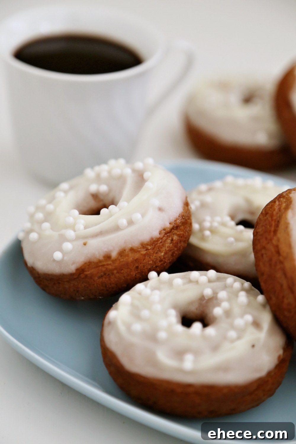 Pillowy Pumpkin Doughnuts with Dreamy Cream Cheese Frosting 7 A stack of soft pumpkin donuts with cream cheese glaze, ready to be enjoyed.