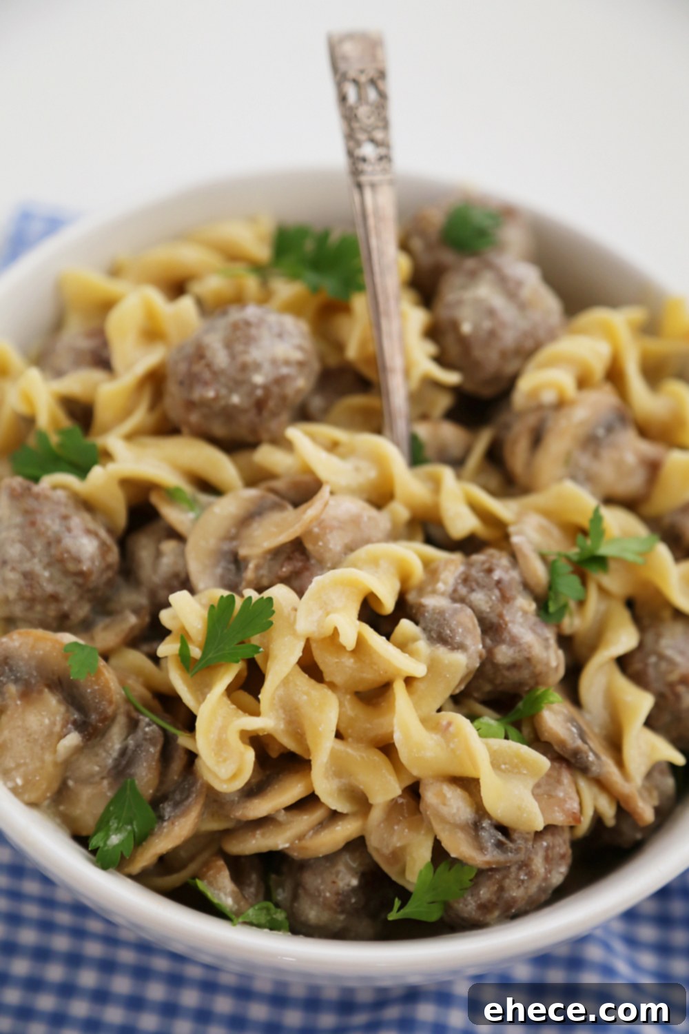 Plate of Creamy Mushroom Meatball Stroganoff with a fork, ready to be enjoyed as a comforting meal.