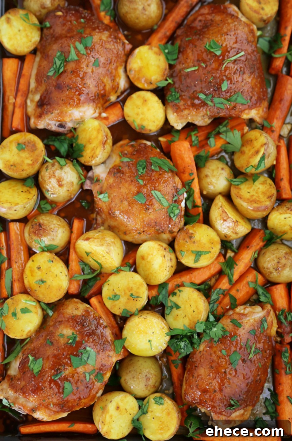 Sheet Pan Garlic Ranch Chicken and Roasted Vegetables 2 Crispy roasted chicken thighs with potatoes and carrots on a baking sheet, fresh out of the oven