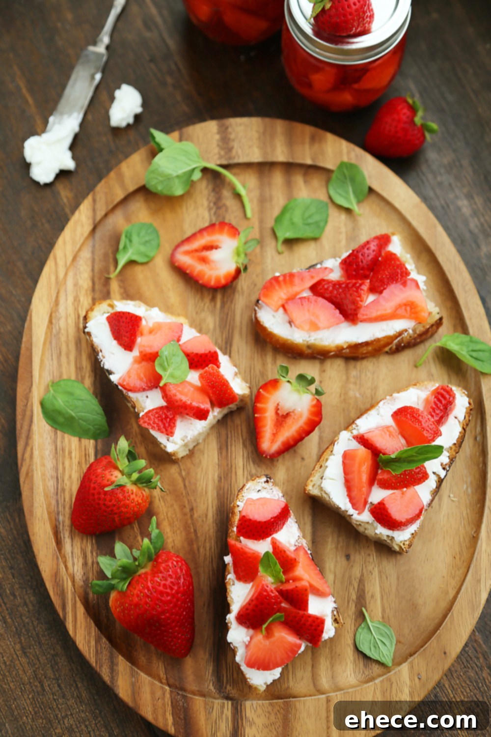 Completed Vanilla Bean Pickled Strawberries with Goat Cheese Crostini on a white serving plate, garnished with mint. Thecomfortofcooking.com