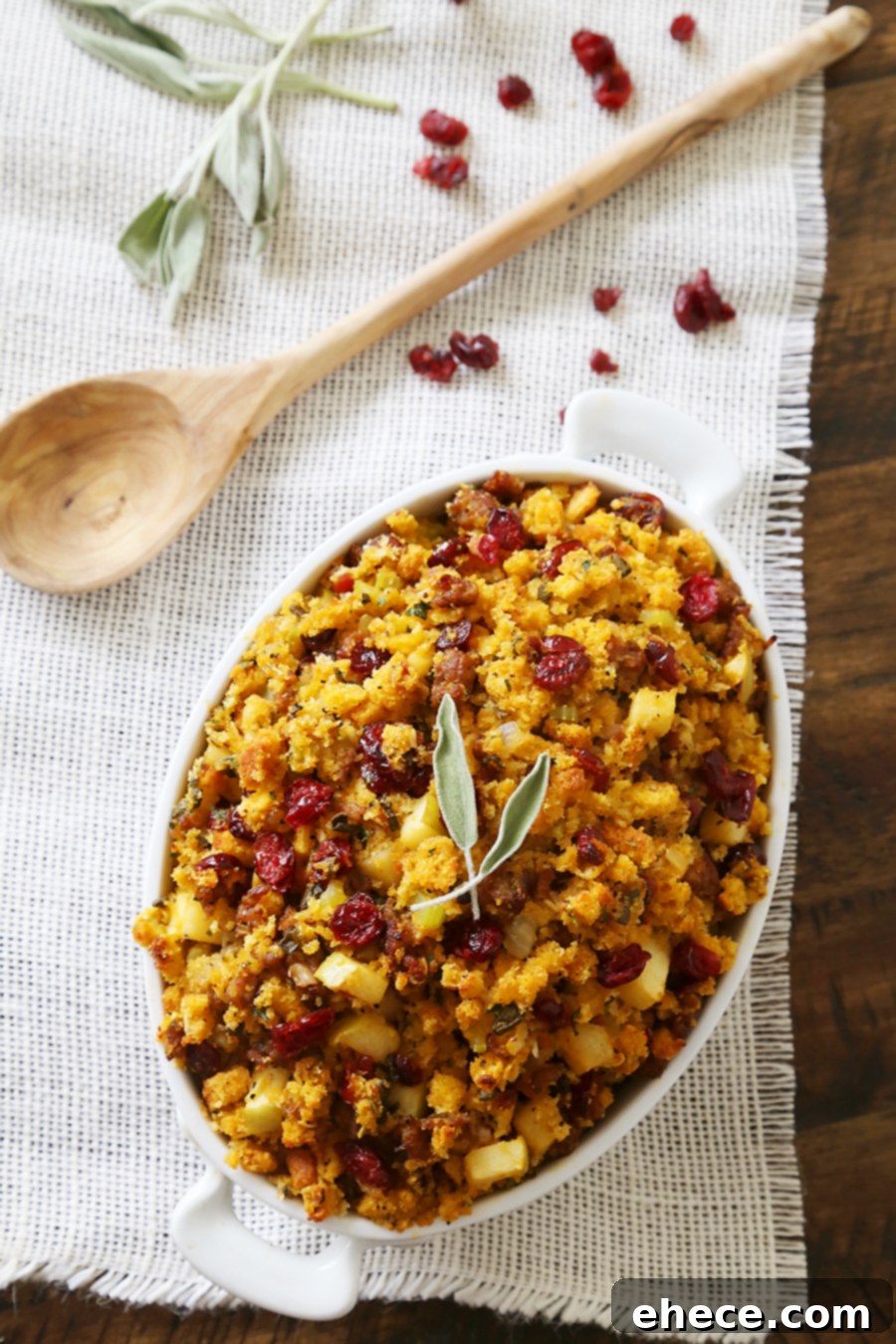 Golden brown Sausage, Apple, and Cranberry Cornbread Stuffing in a baking dish, ready to serve.