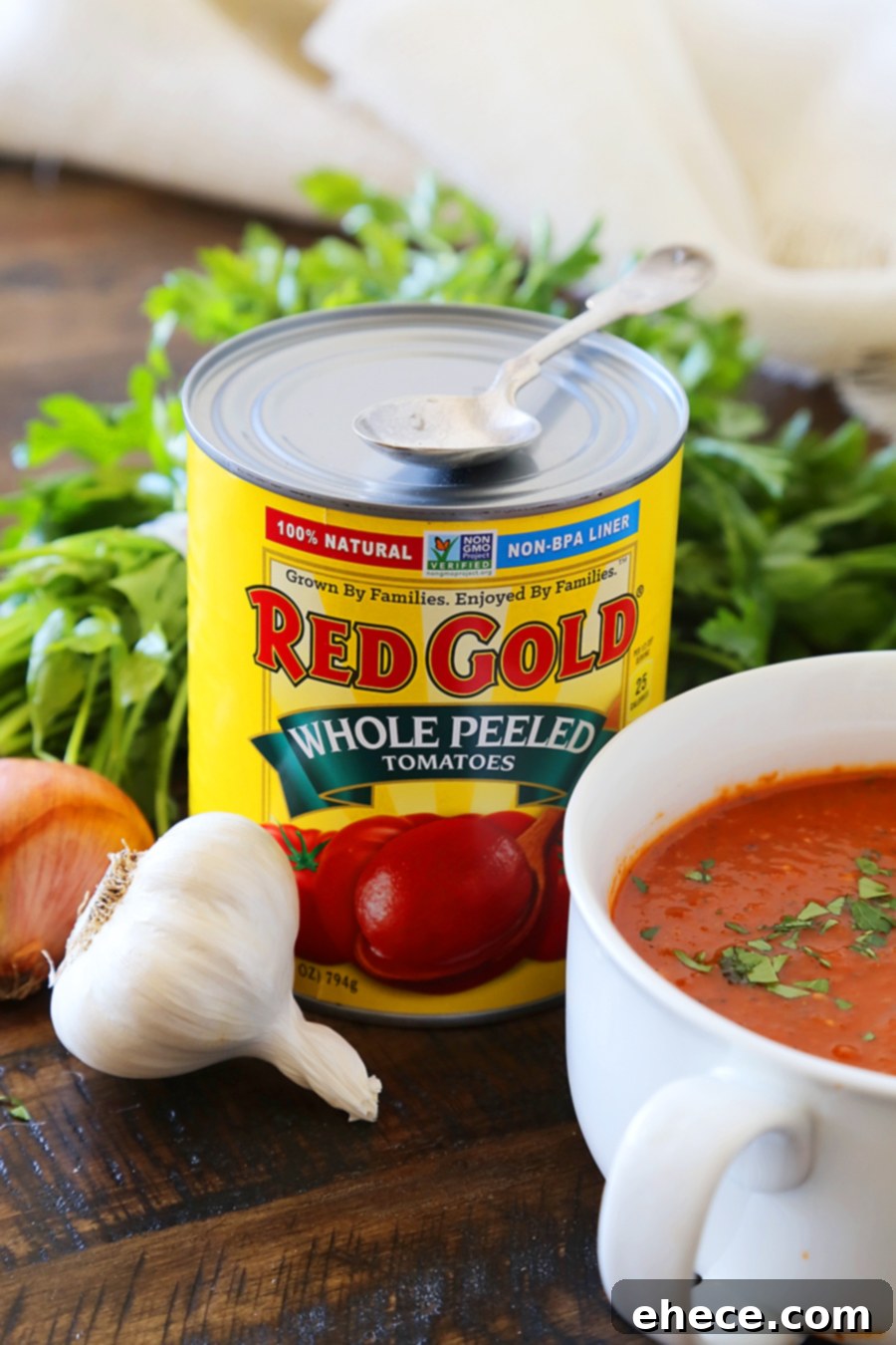 A generous serving of rich Tomato Basil Soup, garnished with fresh basil and a scattering of crispy Grilled Cheese Croutons.