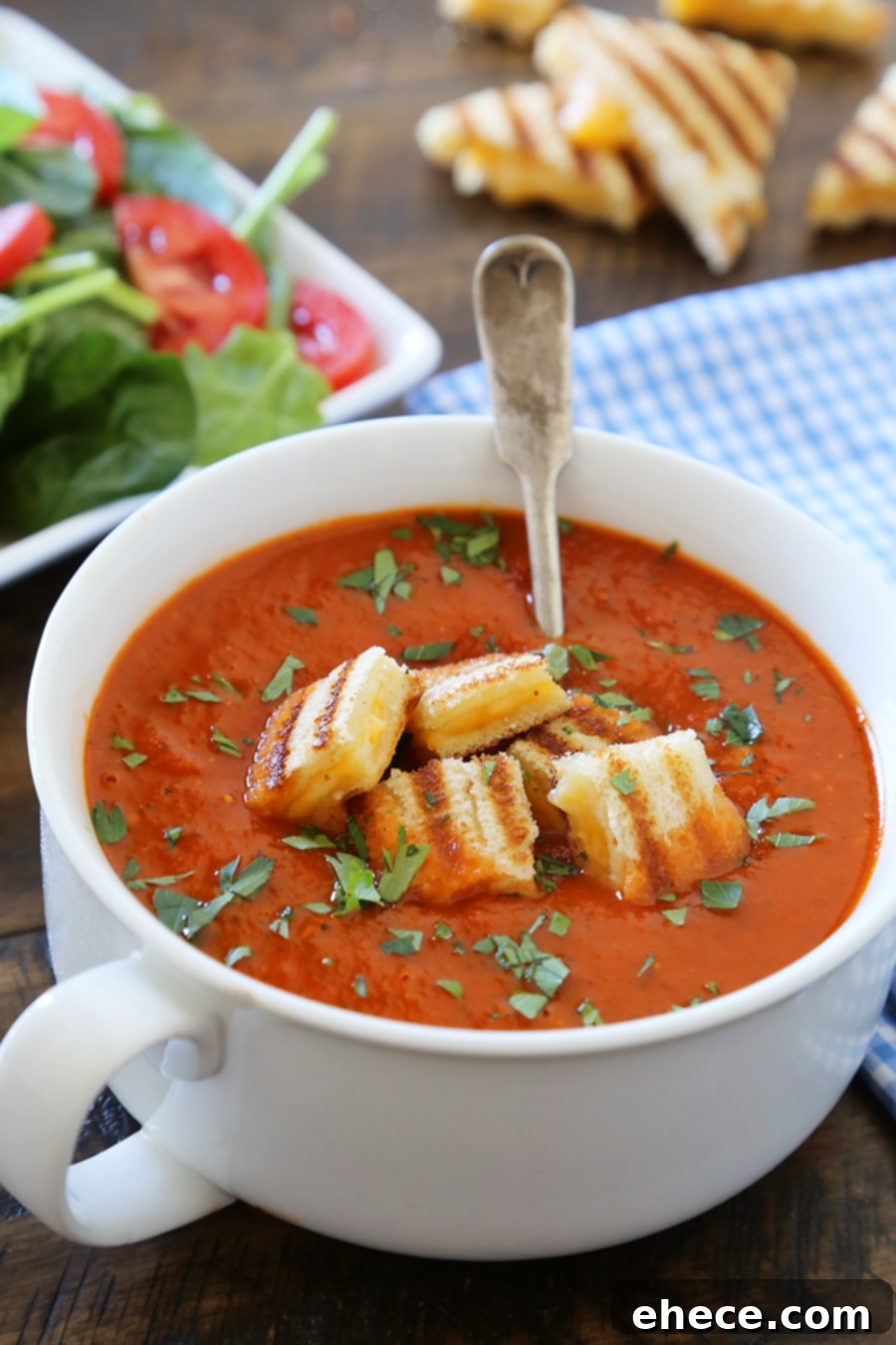 Warm and inviting Tomato Basil Soup in a mug, perfect for cozy comfort, topped with mini grilled cheese croutons.