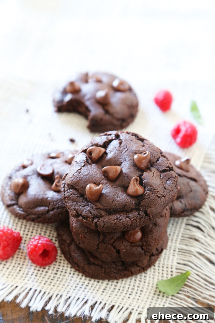 Individual double chocolate cookie broken in half, revealing its chewy texture and molten chocolate center, highlighting its deliciousness.