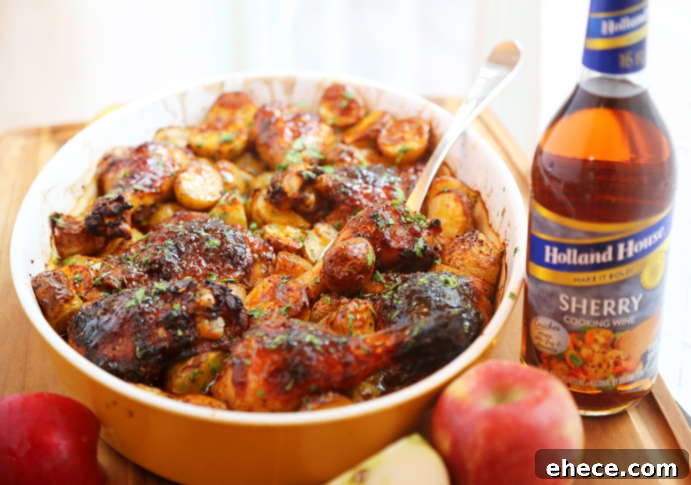 Serving platter featuring roasted apple cider chicken, crisp potatoes, and caramelized onions, garnished with fresh rosemary.