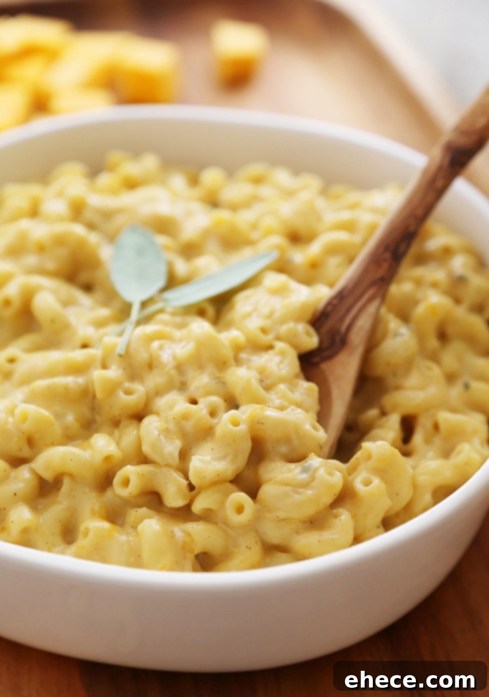 A serving of butternut squash mac and cheese in a bowl, garnished with sage