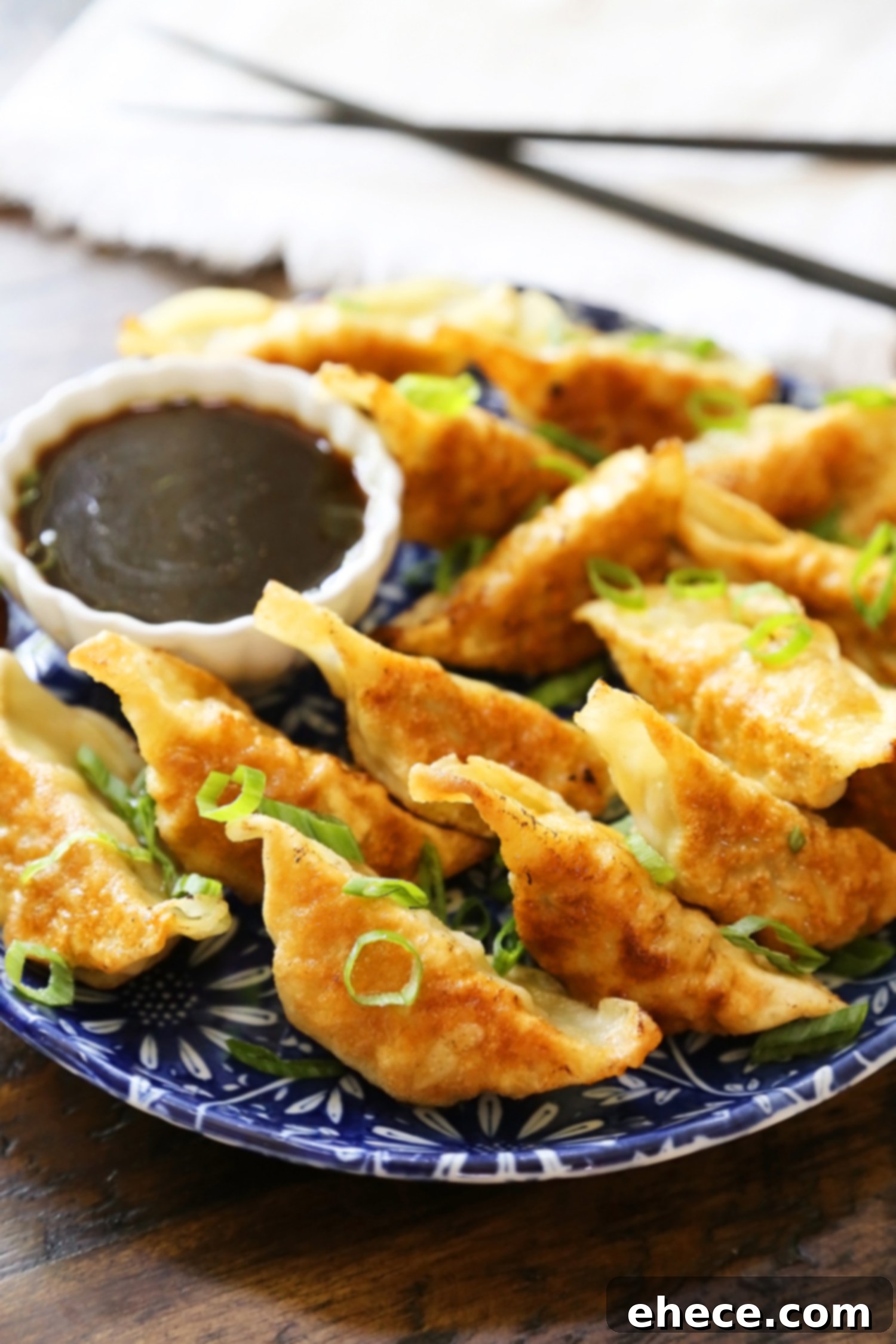 Simple Asian Dumplings with Zesty Soy Ginger Dip 3 Easy Asian Dumplings with Soy-Ginger Dipping Sauce - Crispy, tender steamed potstickers, made easily in one skillet! A plate of perfectly cooked potstickers, some showing their crispy bottoms.