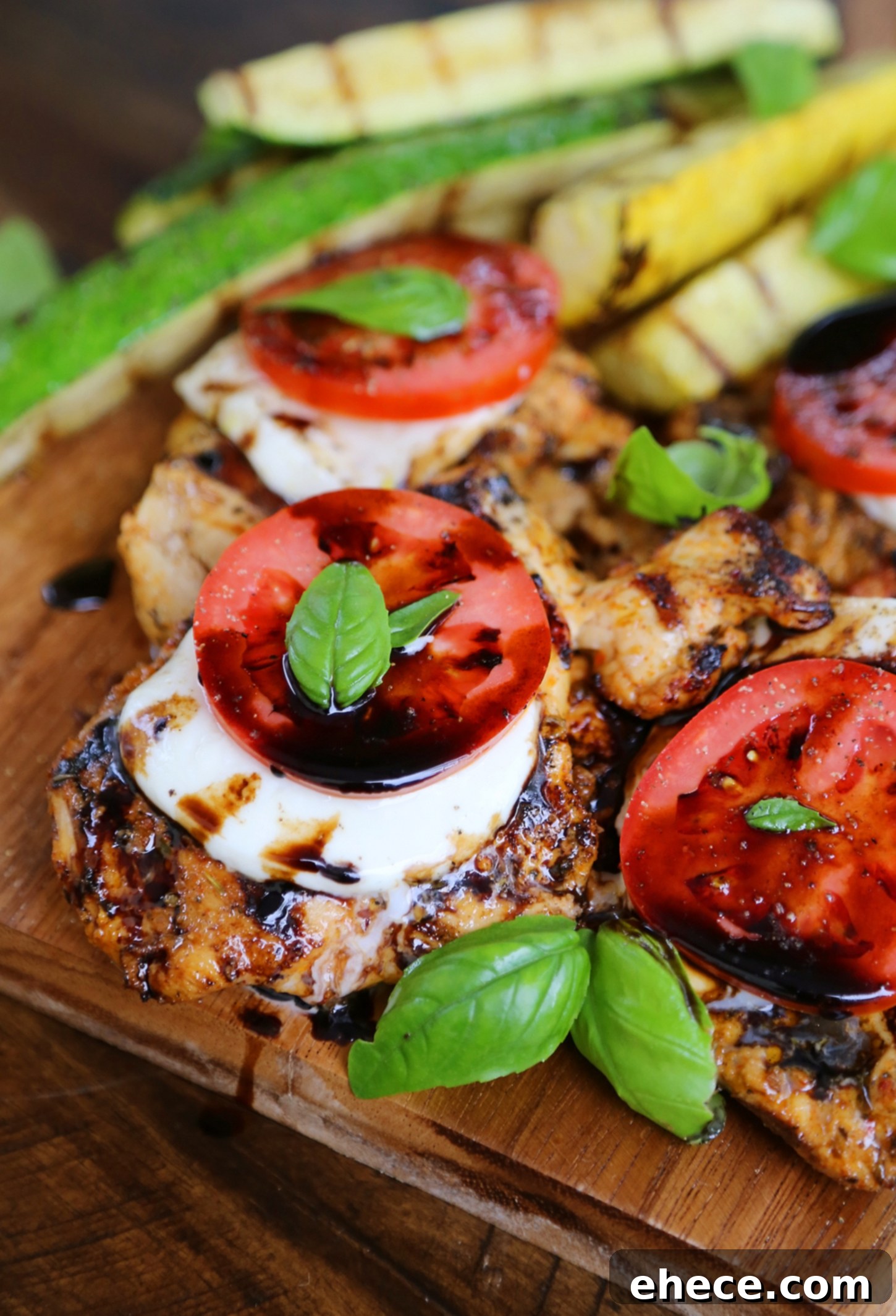 Vibrant Caprese Chicken with Grilled Summer Squash 4 Two pieces of grilled Caprese chicken with summer squash on a plate