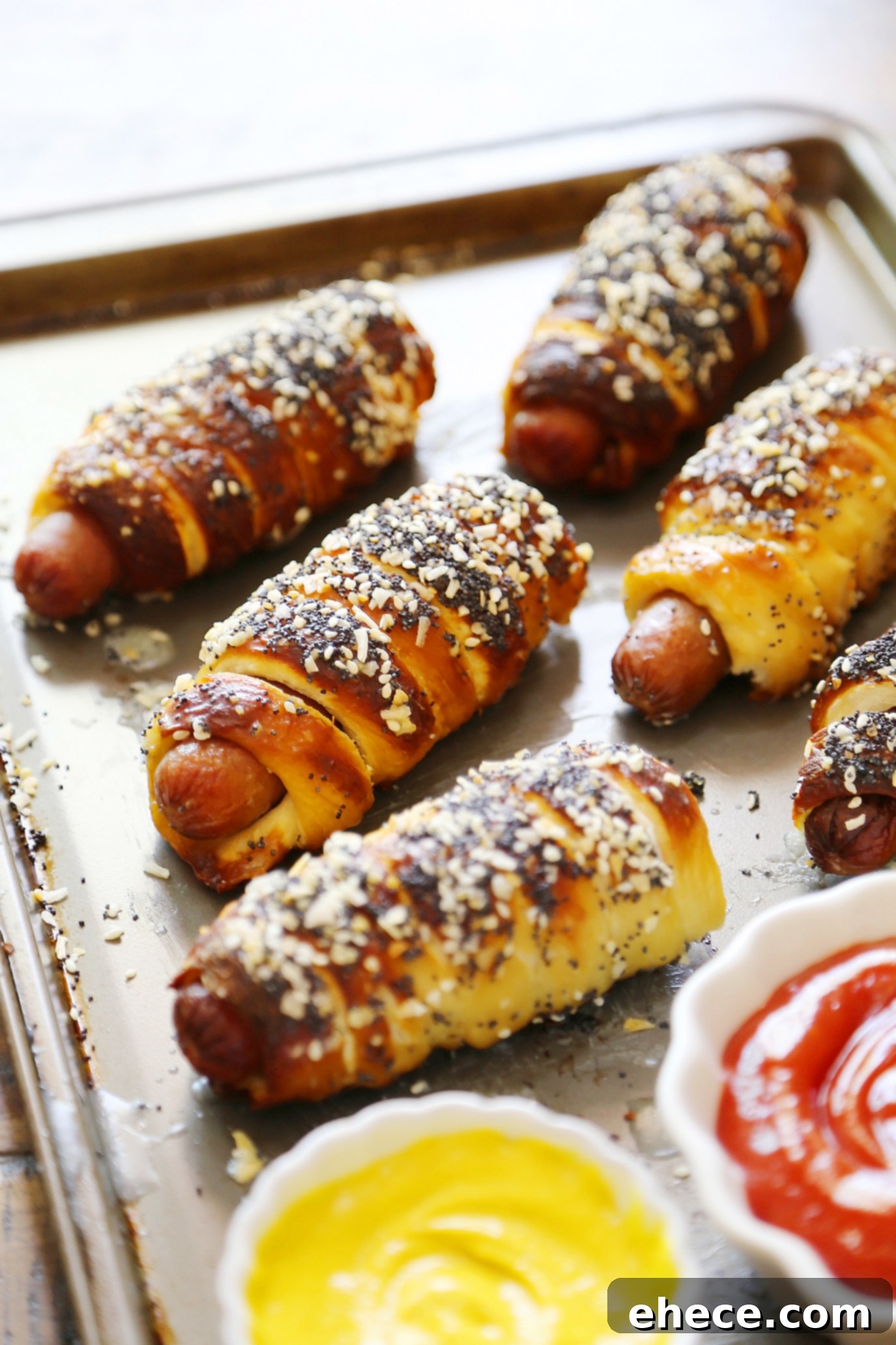 Freshly baked everything pretzel dogs with a dipping sauce