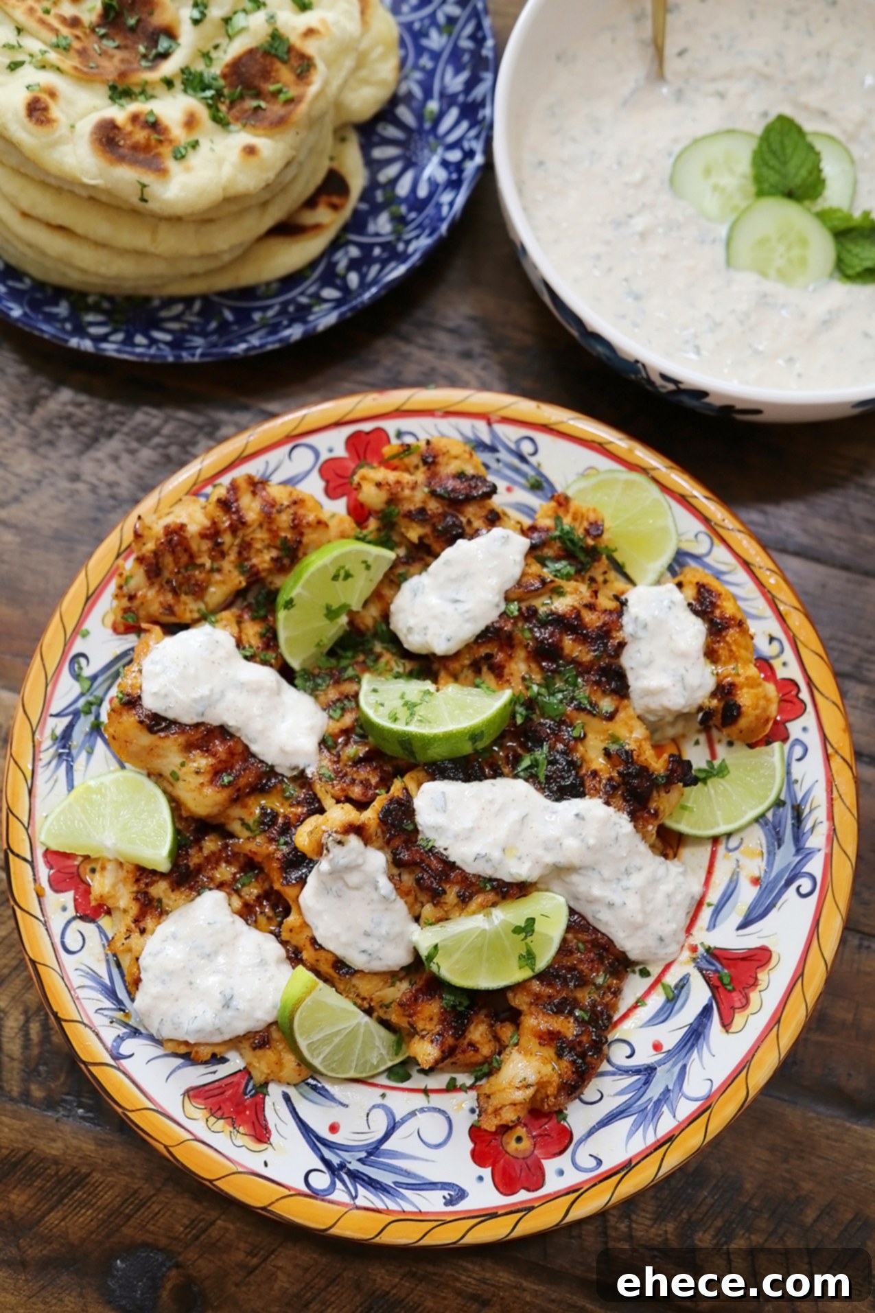 Sizzling Chili Lime Chicken with Refreshing Cucumber Mint 6 Close-up of a plate with Chili-Lime Grilled Chicken, a dollop of Cucumber-Mint Sauce, and lime wedges.