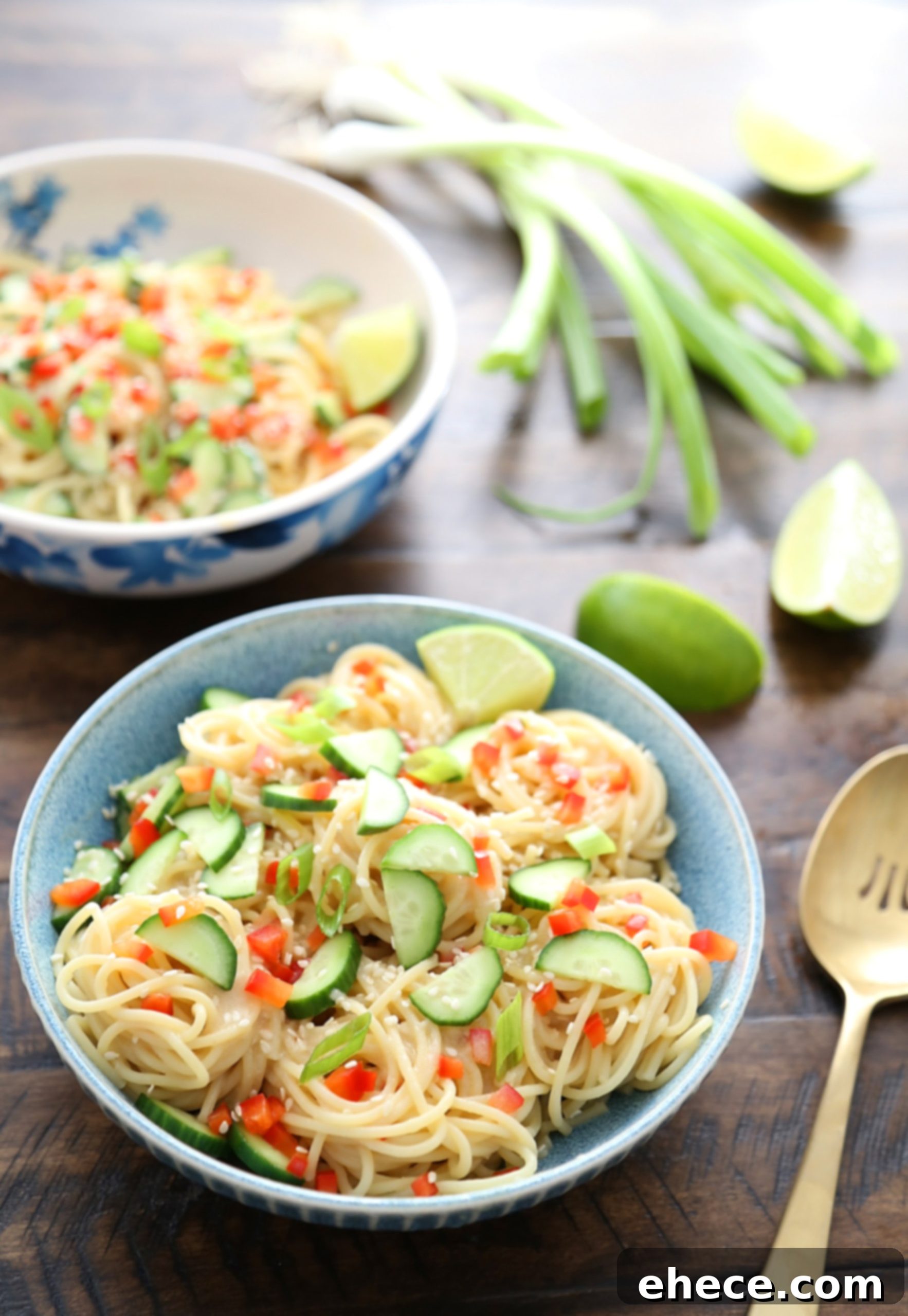 A vibrant bowl of Cold Sesame Cucumber Noodle Salad with chopsticks ready to serve.