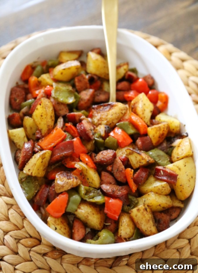 Delicious one-pan roasted sausage, peppers, and potatoes on a baking sheet, ready to serve.