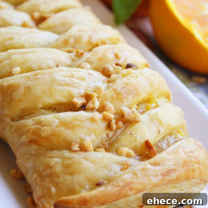 Golden brown Orange Cheese Danish Pastry topped with orange glaze and walnuts