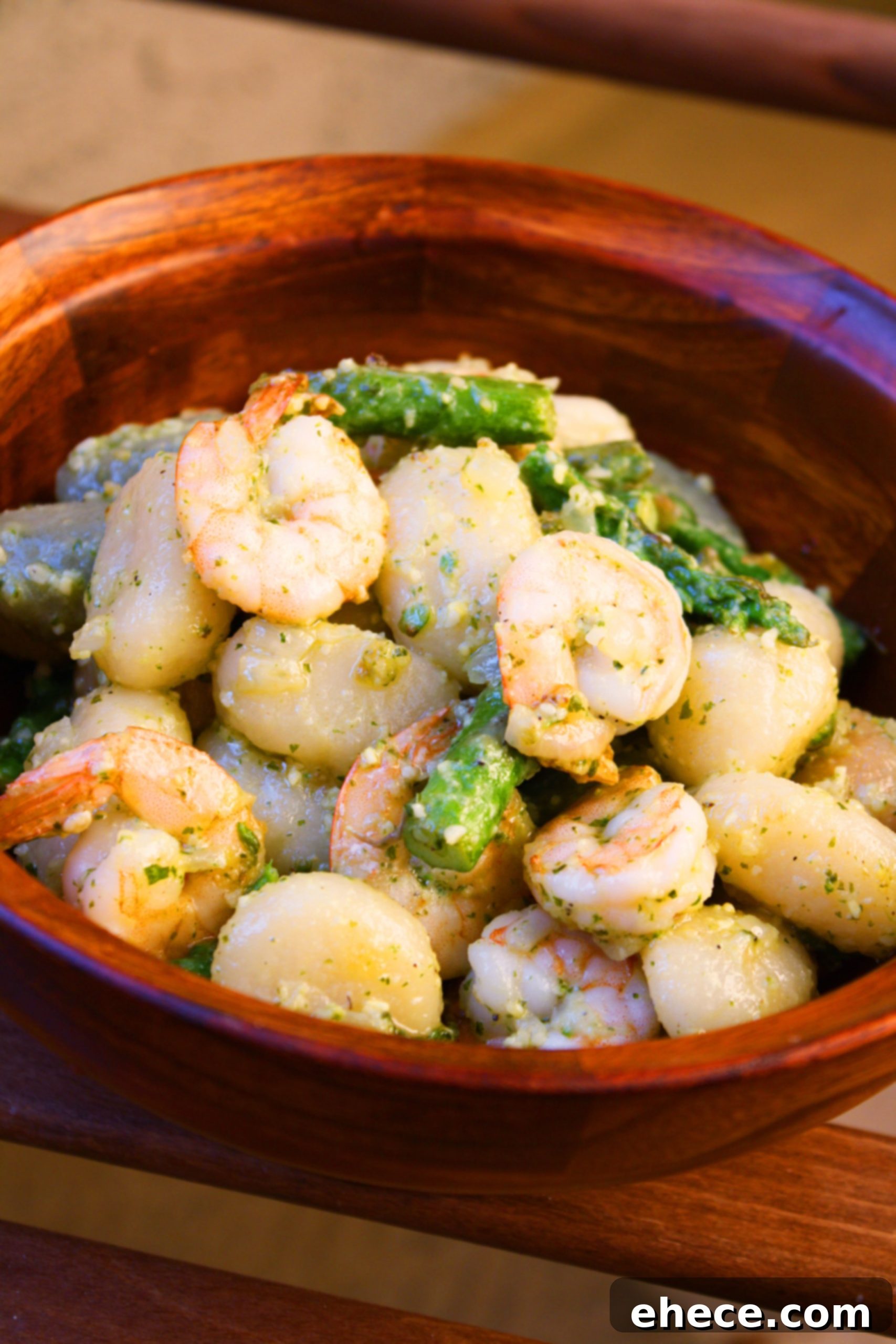 Fresh Basil Pesto Gnocchi with Sautéed Shrimp and Asparagus 2 Gnocchi with Shrimp, Asparagus, and Pesto in a pan, topped with Parmesan.