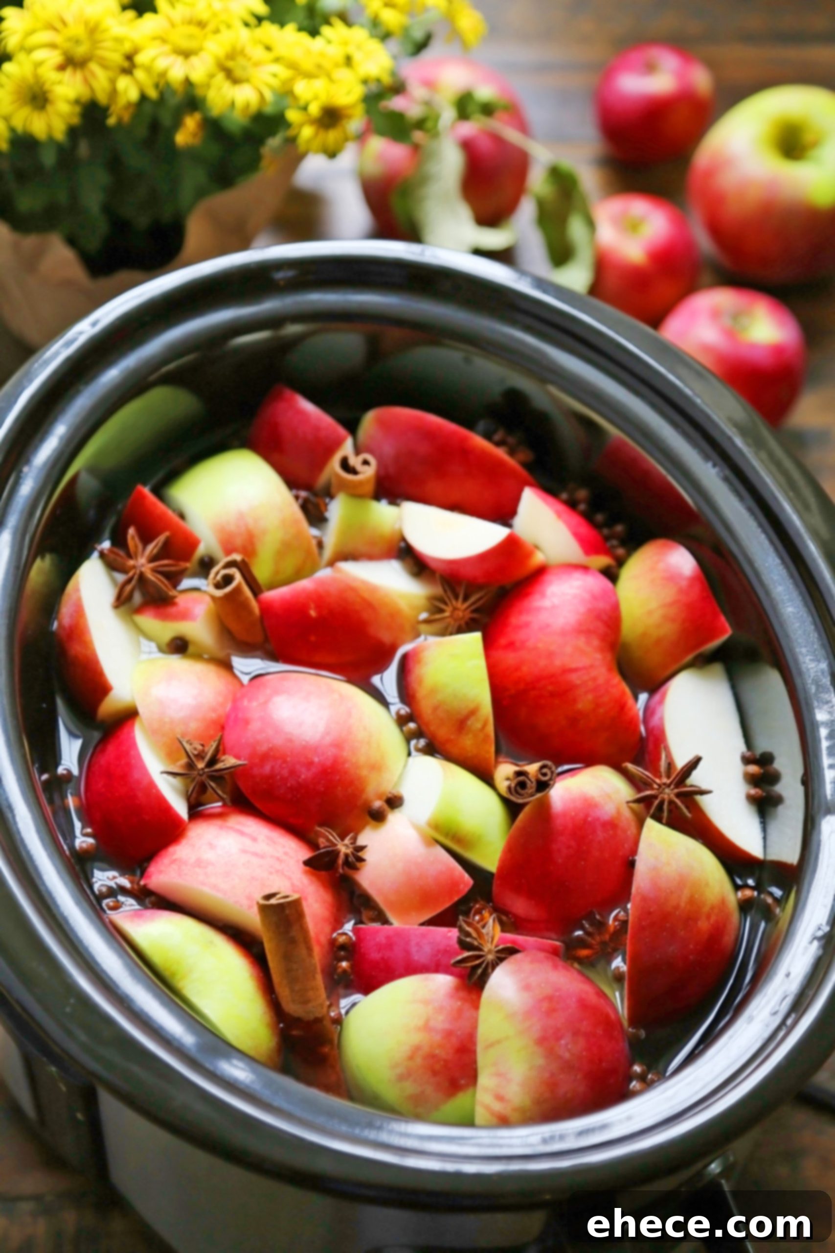 Apples and spices simmering in a slow cooker for cider