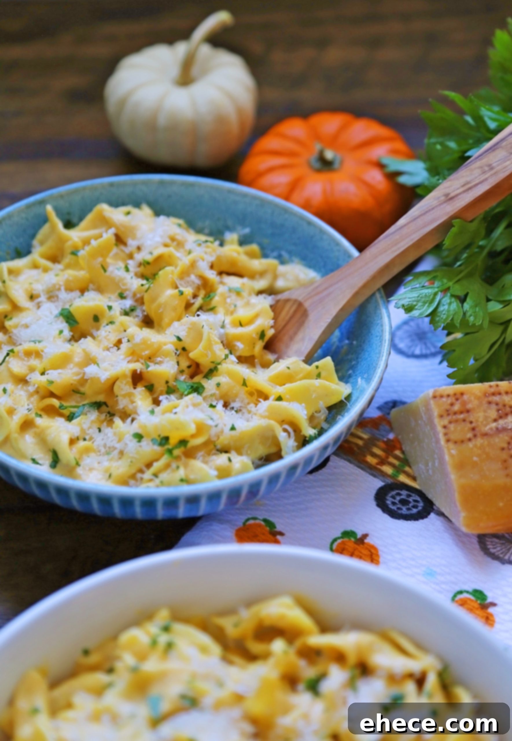 Four bowls of Creamy Pumpkin Alfredo pasta, garnished with herbs and Parmesan