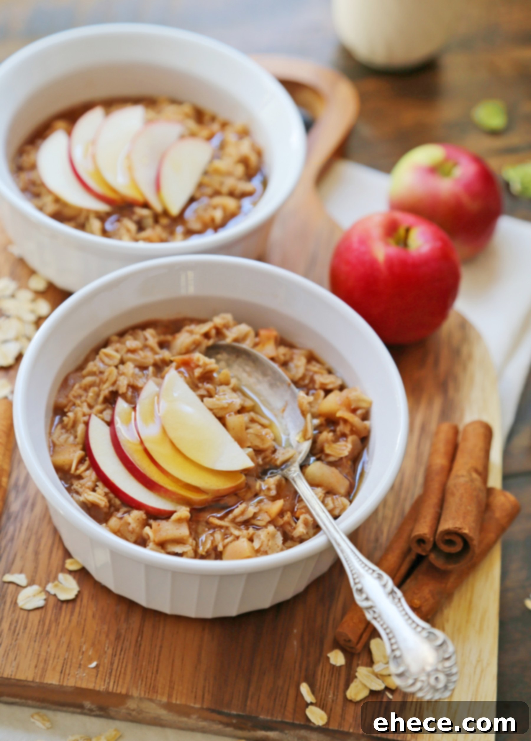 Old-fashioned oats cooking on the stovetop, absorbing liquid and becoming creamy amidst the tender apple pieces and spices.