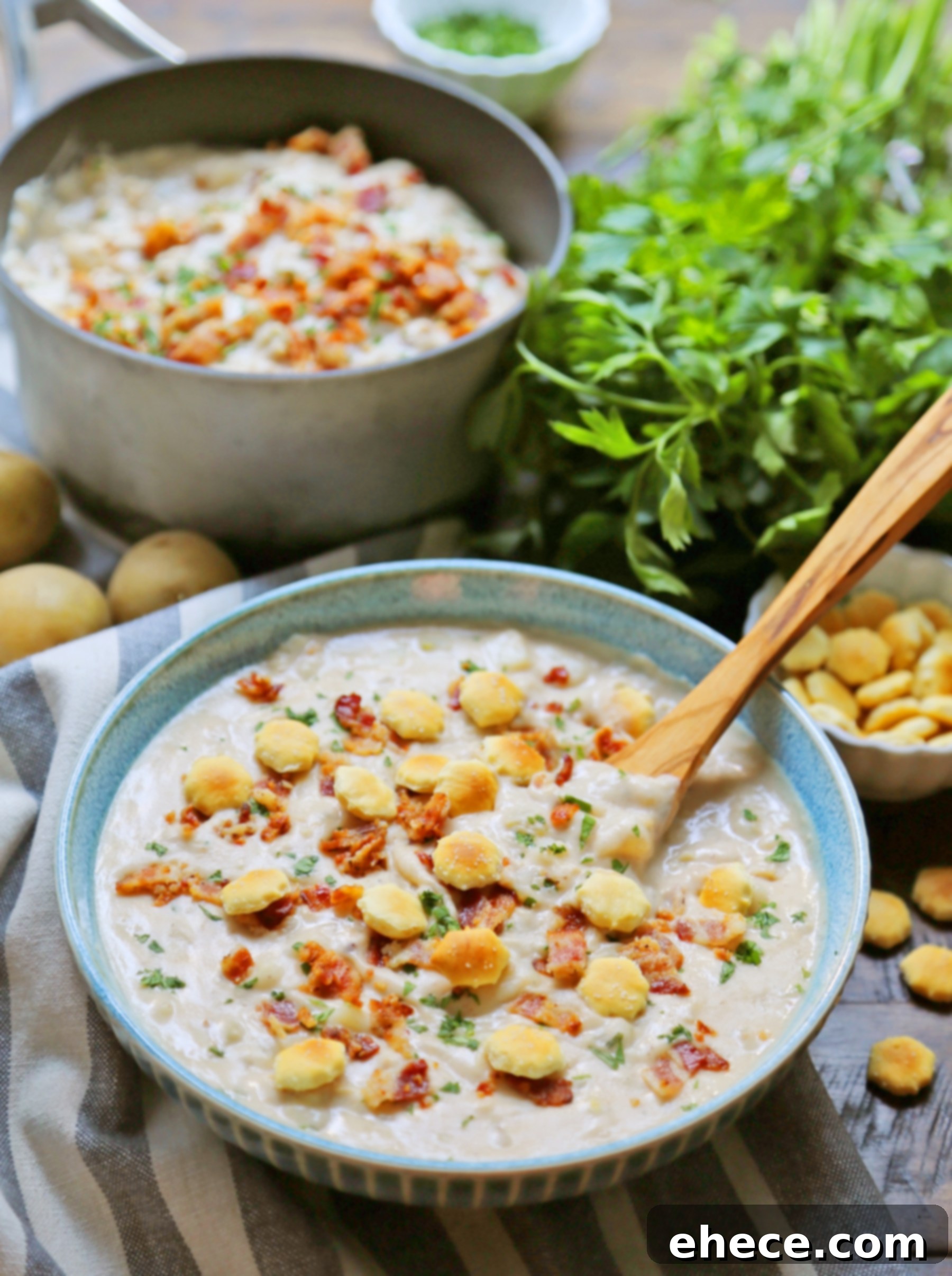 Steaming bowl of homemade clam chowder with bacon and bread