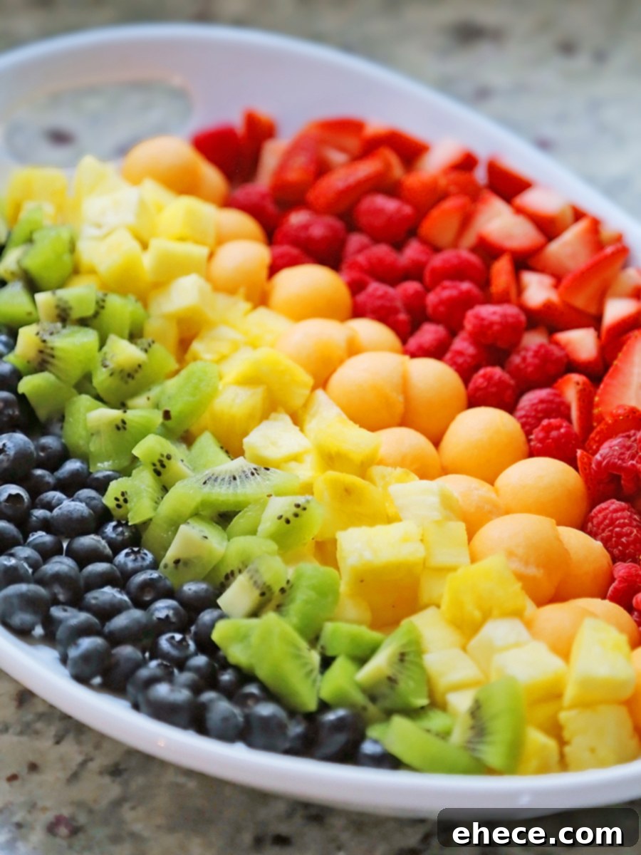 A top-down view of the colorful rainbow fruit salad, highlighting the arrangement of various fresh fruits on a platter.