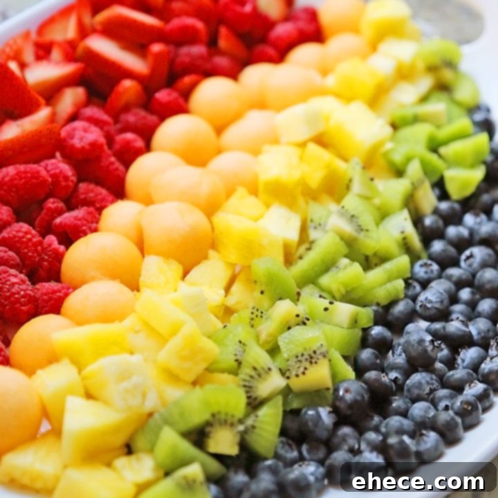 Rainbow Fruit Salad with various colorful fruits arranged on a platter, ready to serve.