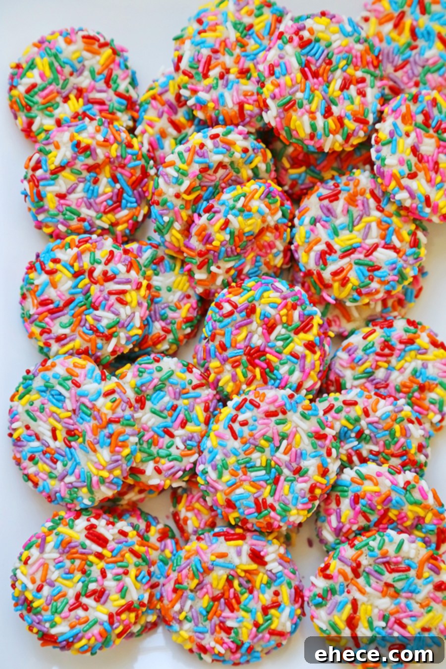 Two Rainbow Sprinkle Cookies broken in half, showing their soft interior
