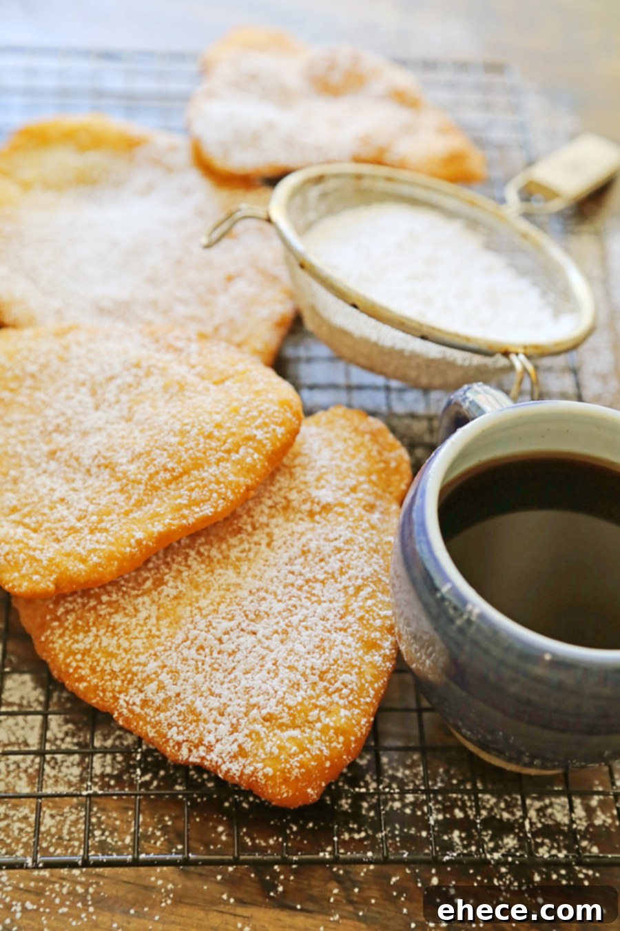 Close-up of a perfectly puffed, golden fried dough piece being lifted from the oil