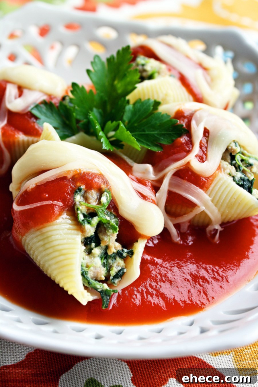 A close-up of baked turkey and spinach stuffed shells, generously topped with melted mozzarella cheese and rich tomato sauce, in a baking dish.