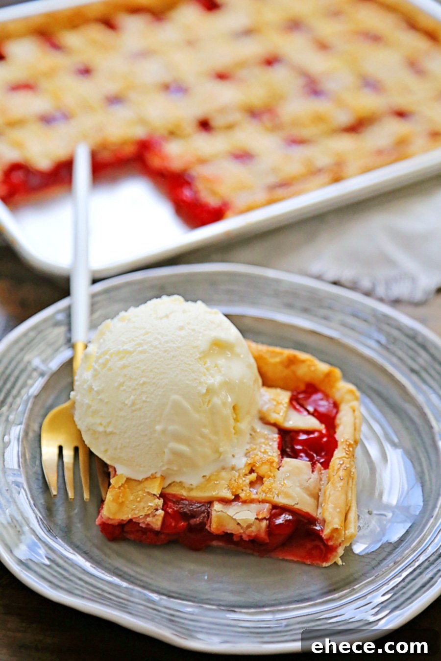 Close-up of a slice of cherry slab pie, showing the flaky crust and juicy cherry filling.