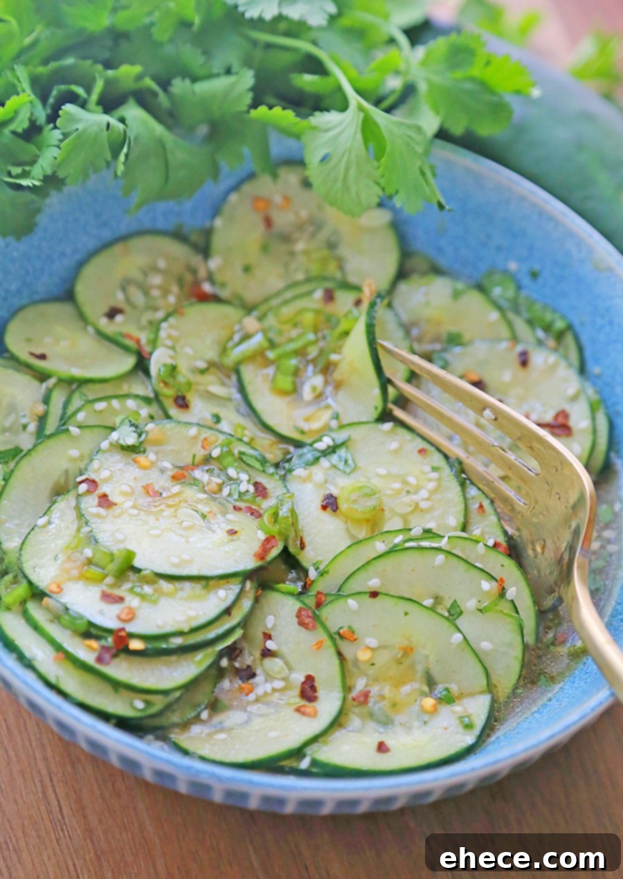 Refreshing Asian Cucumber Crunch 2 10-Minute Asian Cucumber Salad - A bowl of fresh, thinly sliced cucumbers with herbs.