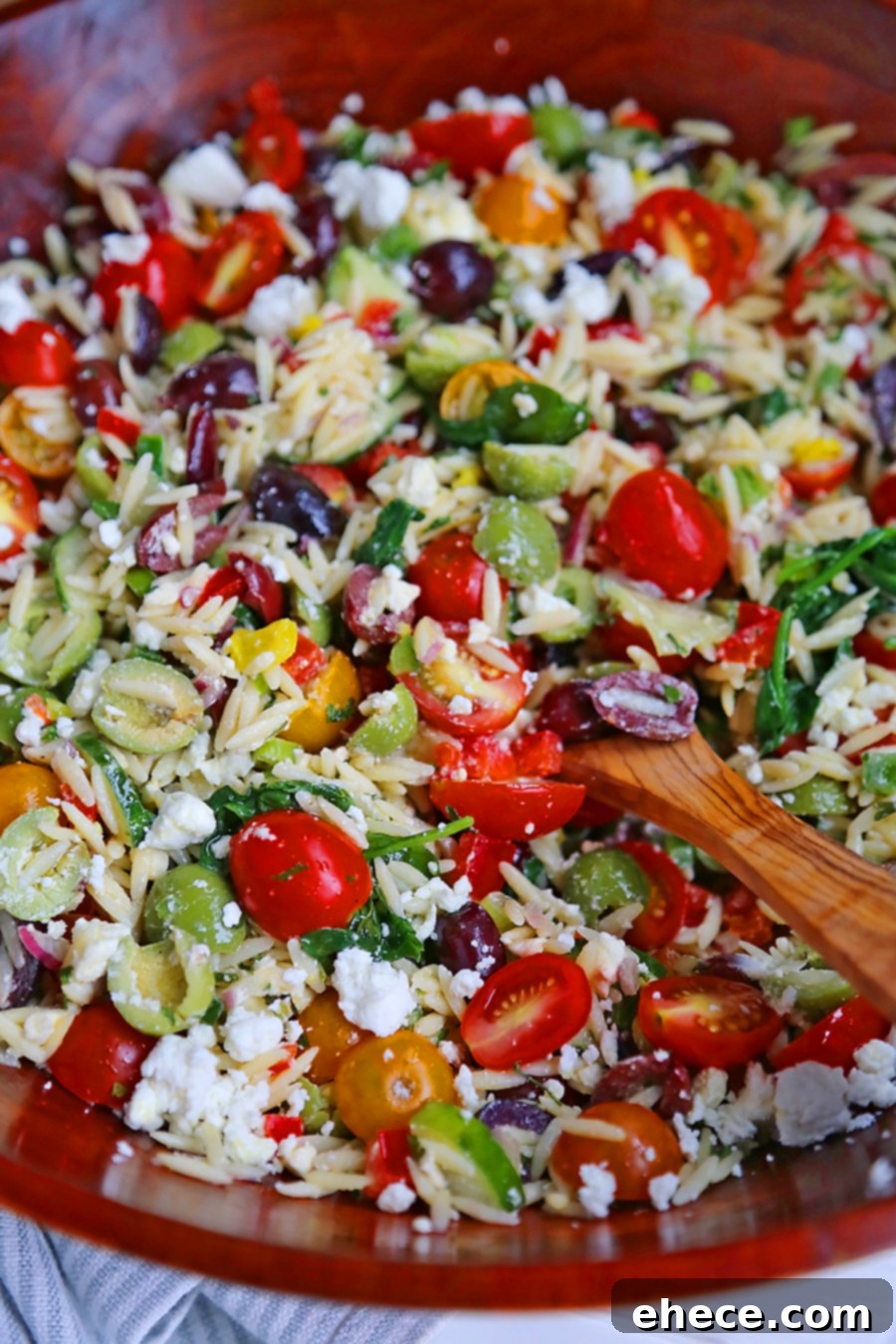 Mediterranean Sunshine Orzo Salad 5 Serving of Mediterranean Orzo Salad with various grilled meats in the background