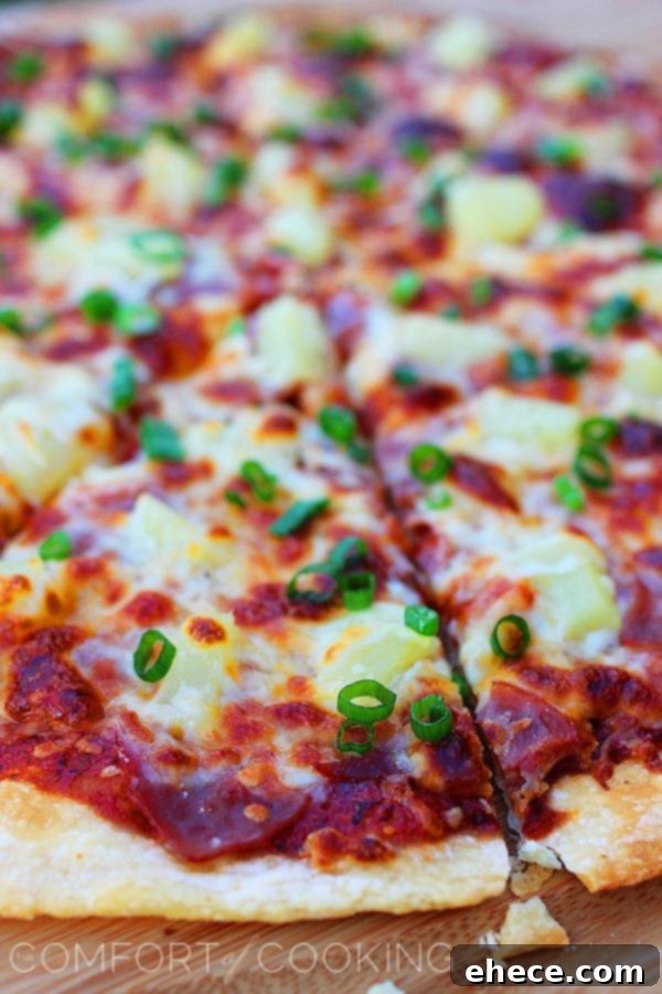 Tropical BBQ Ham Pizza 3 Close-up of a freshly baked BBQ Ham and Pineapple Pizza, showing melted cheese and toppings