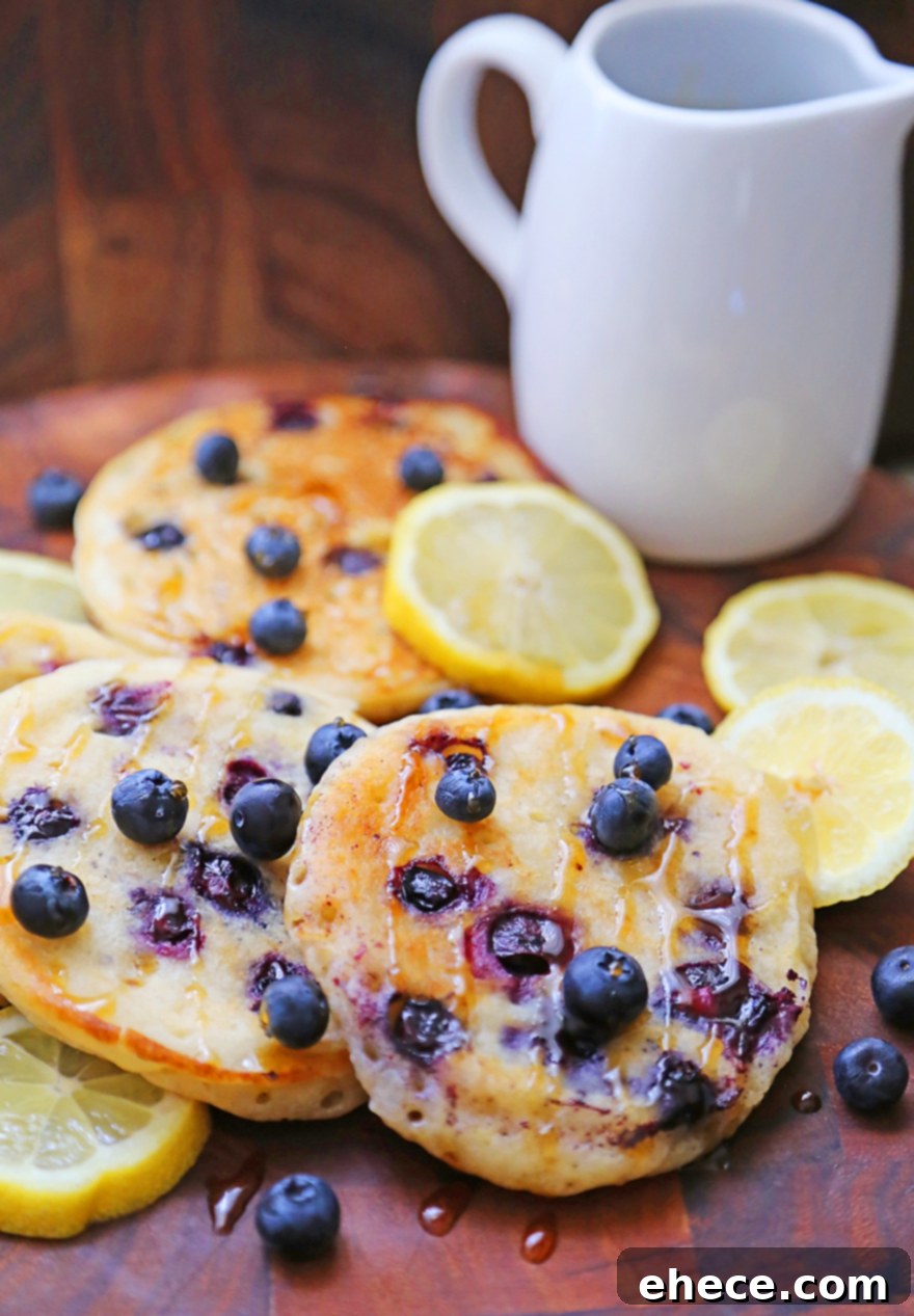 Pillowy Lemon Blueberry Ricotta Pancakes 4 Pancakes with blueberries and syrup