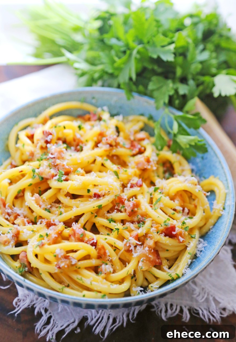 Close-up of a fork twirling creamy Bucatini Carbonara with crispy pancetta