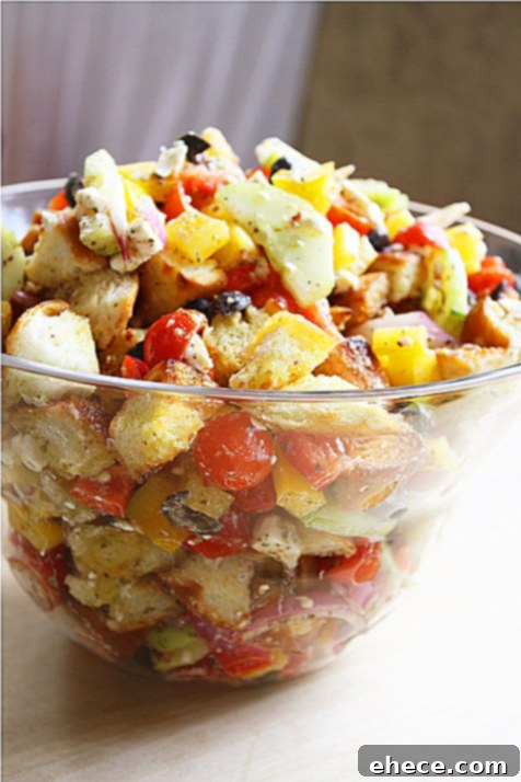A close-up of vibrant, fresh vegetables and bread cubes, ready to be transformed into Greek Panzanella Salad.