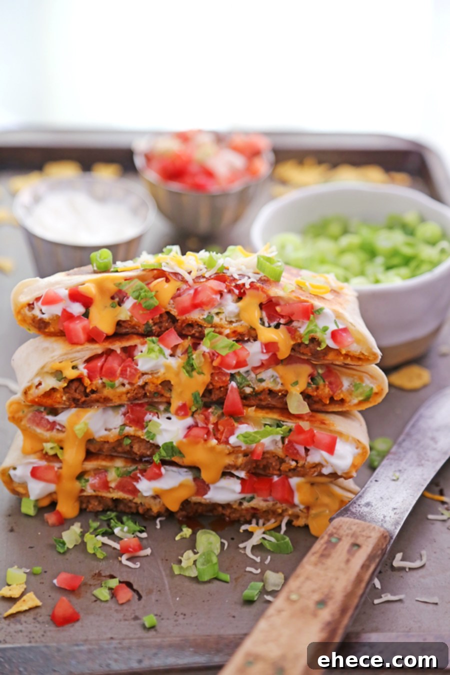 Sliced homemade Crunchwrap Supreme with all the layers visible, on a cutting board
