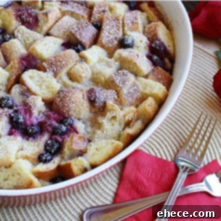 Berry Patch Layers 2 Delicious Berry Strata topped with powdered sugar and fresh berries, ready for brunch.