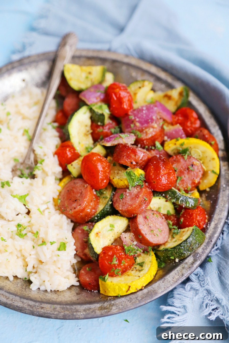Easy One-Pan Sausage, Zucchini, and Tomato Dinner 3 Close-up of roasted sausage and vegetables on a sheet pan