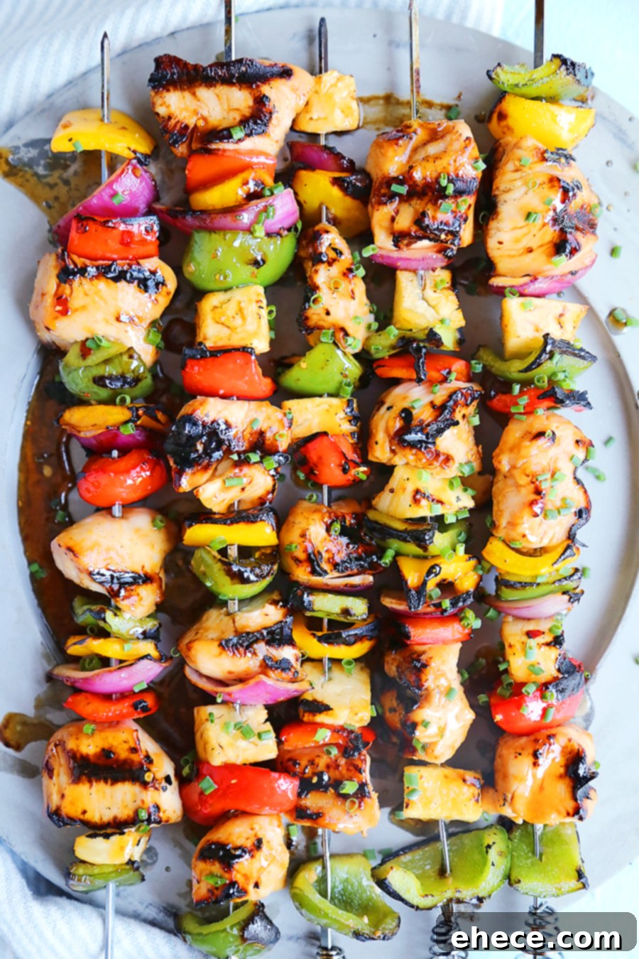 Island Glazed Chicken Skewers 6 Sweet Chili Hawaiian Chicken Skewers arranged artfully on a wooden board