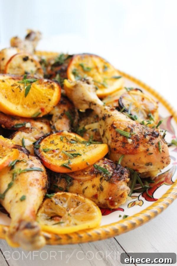 Cooked herb and citrus roasted chicken on a serving platter with garnishes.