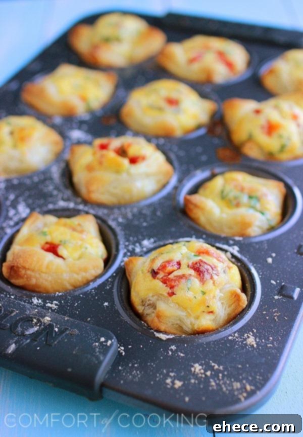 Flaky Golden Quiche Bites 3 Close-up of freshly baked mini quiches with vibrant fillings of roasted red peppers and green herbs, showcasing their appealing texture.