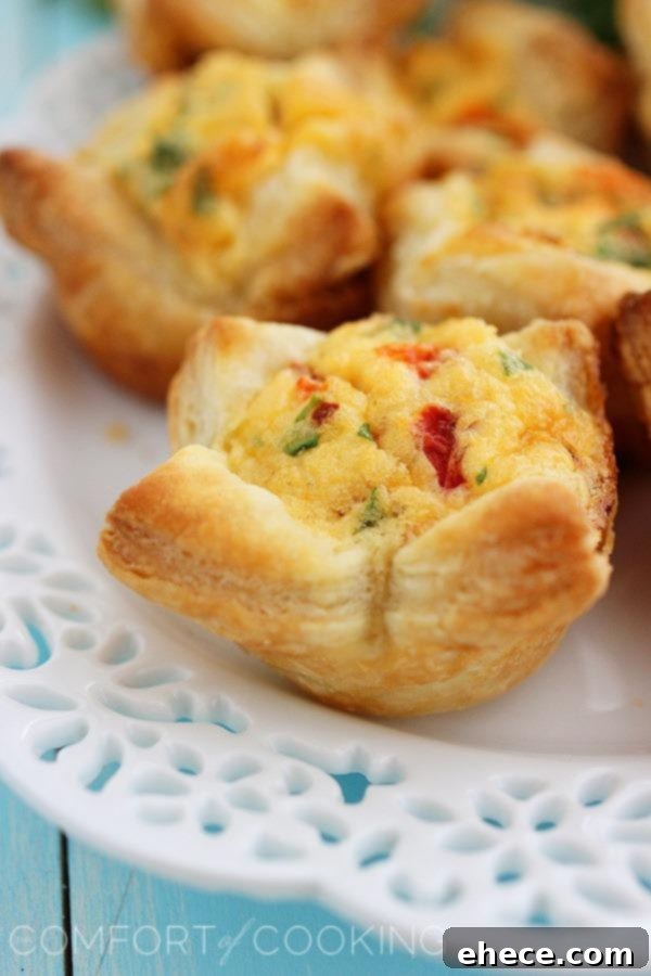Flaky Golden Quiche Bites 4 A beautiful arrangement of assorted mini puff pastry quiches on a rustic serving platter, highlighting their perfect golden brown finish.