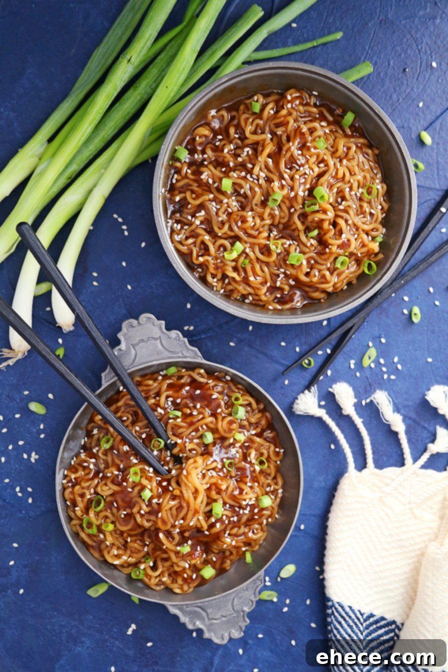 Close-up of freshly cooked ramen noodles being tossed with the savory sauce in a pot.