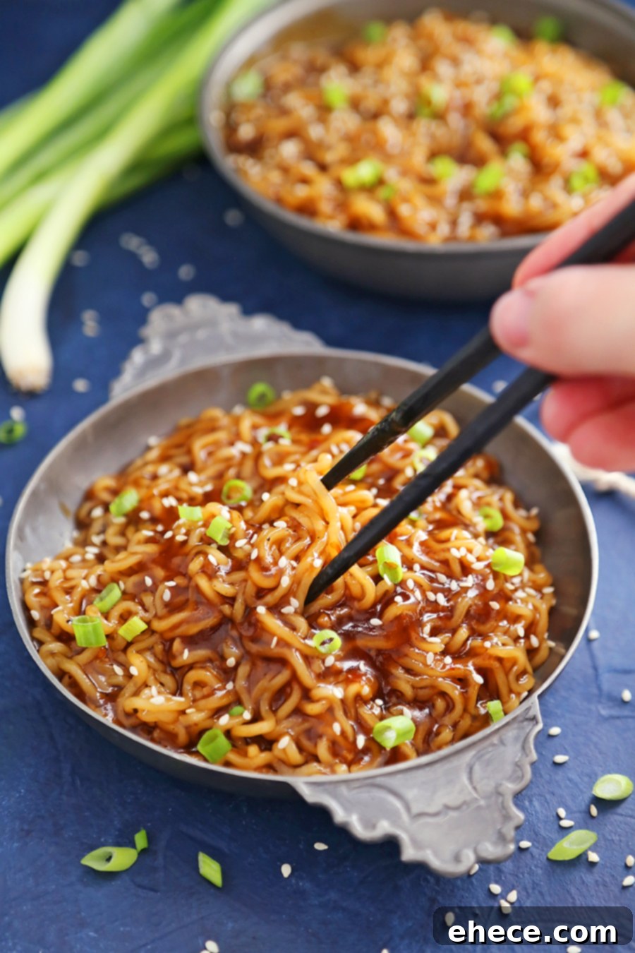 A close-up shot of the finished saucy ramen noodles in a bowl, ready to be eaten.