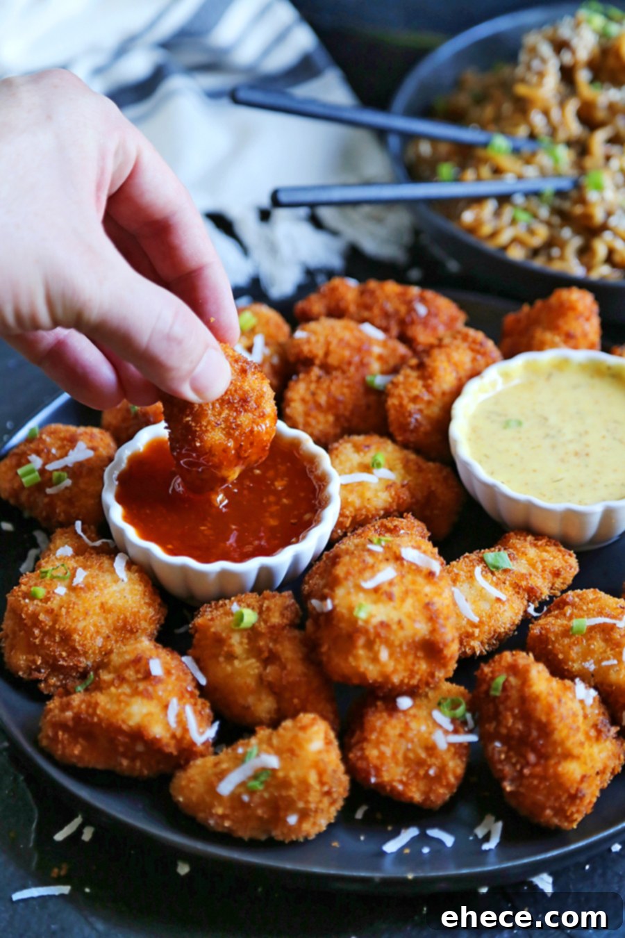 Tropical Crunch Popcorn Chicken 5 A festive table setting featuring Crispy Coconut Popcorn Chicken, ramen, and salad, ideal for gatherings