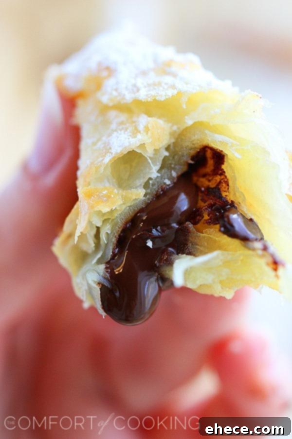 3-Ingredient Chocolate Croissant Hack 7 Baked chocolate croissants dusted with powdered sugar, ready to be served.