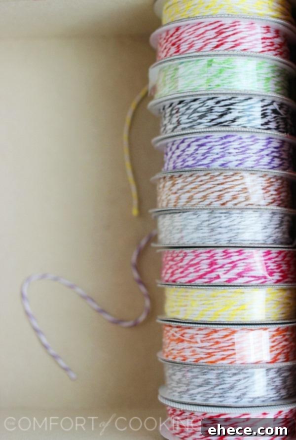 Crafting personalized tea tags: cardstock, decorative hole punch, glue stick, and twine.