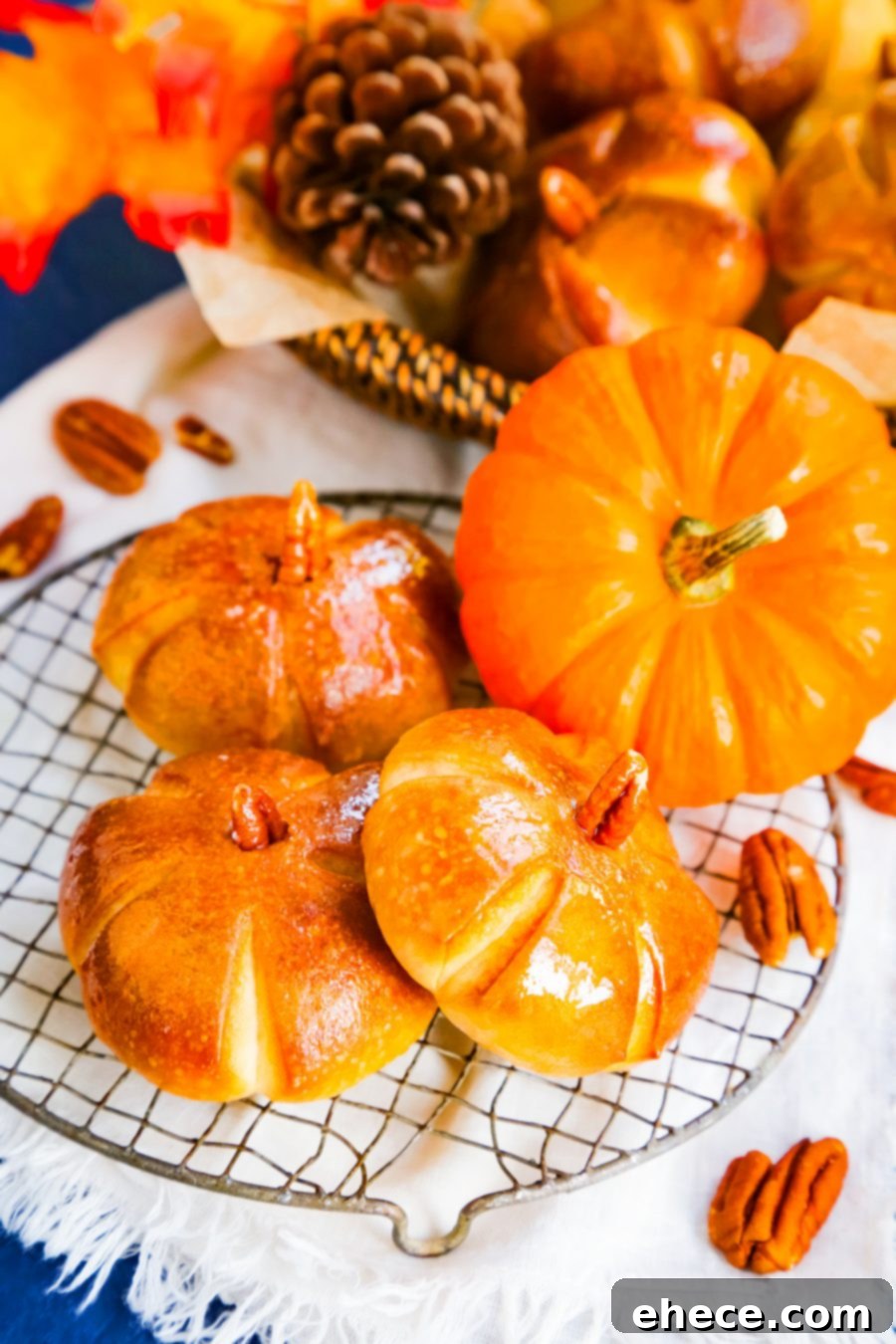 Overhead shot of freshly baked pumpkin dinner rolls arranged on a wooden board.