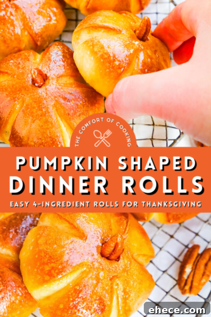 A close-up shot of a single pumpkin dinner roll with a pecan stem on a wooden surface.